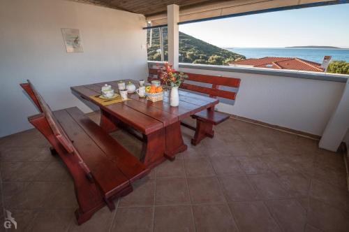 a table and chairs on a balcony with a view of the ocean at Villa Goga in Martinšćica