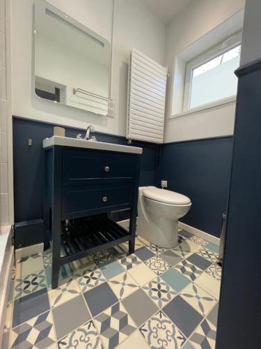 une salle de bain avec un lavabo noir et des toilettes dans l'établissement Appartement Malouin - Villa Leopold, à Dunkerque