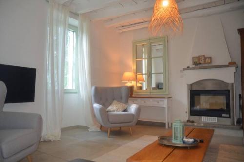 a living room with a chair and a fireplace at Casa Lario in Naggio