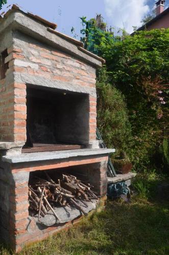 a brick oven with a pile of wood in it at Casa Lario in Naggio