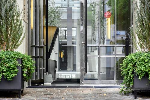 a glass door of a building with two potted plants at H15 Boutique Hotel, Warsaw, a Member of Design Hotels in Warsaw