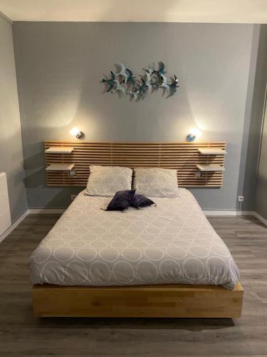 une chambre avec un grand lit avec une tête de lit en bois dans l'établissement Studio proche des falaises, du port et des plages, au Tréport