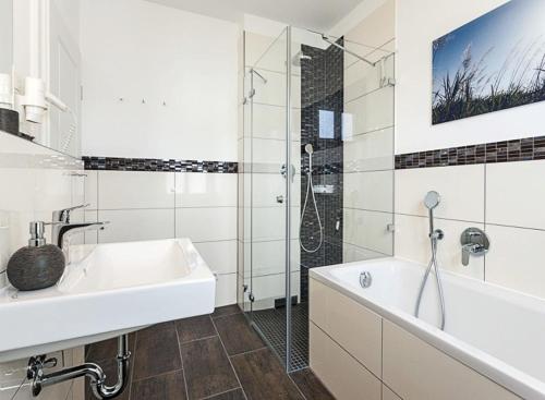 y baño con bañera, lavamanos y ducha. en Villa Fabiola in Strandnähe, en Binz