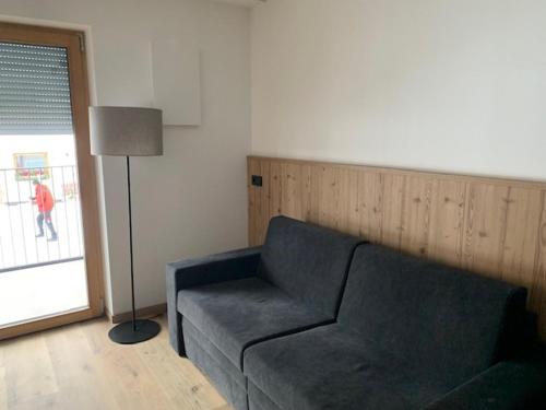 a living room with a couch and a lamp at Dependance Residence Altea in Ortisei