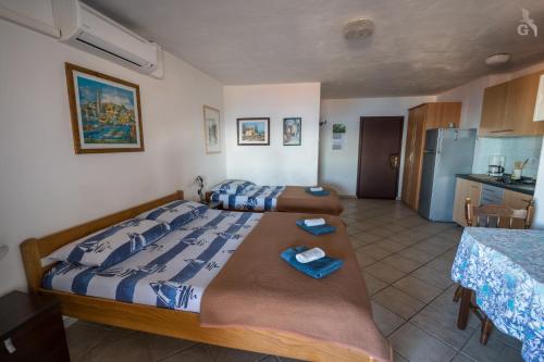 a bedroom with two beds and a kitchen at Villa Goga in Martinšćica