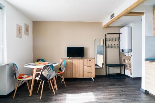 een woonkamer met een tafel en stoelen en een televisie bij Stay in Cervinia Deluxe Apartment in Breuil-Cervinia