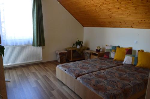 ギェネシュディアーシュにあるZsuzsa Apartmanの木製の天井のベッドルーム1室(大型ベッド1台付)