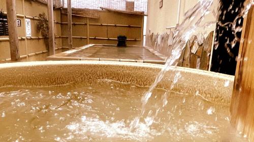 a water fountain in the middle of a building at Capsule Hotel Topos Sendai Station Nishiguchi in Sendai