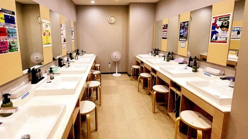 a bathroom with a row of sinks and mirrors at Capsule Hotel Topos Sendai Station Nishiguchi in Sendai