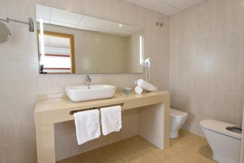 a bathroom with a sink and a toilet and a mirror at Hotel Internacional in Calella