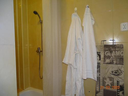 a bathroom with a shower and a white robe at Blue Mielno - Dom Gościnny in Mielno