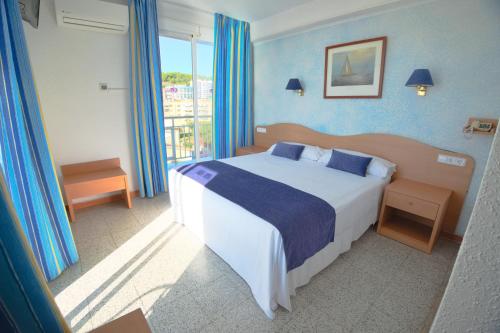 カレーリャにあるHotel Internacionalの青い壁のベッドルーム1室(大型ベッド1台付)