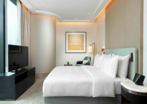 a bedroom with a large white bed and a television at Address Istanbul in Istanbul