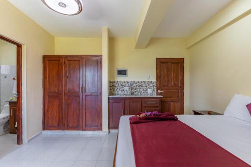 a bedroom with a bed with a red blanket on it at Hotel Turístico Marian in Las Terrenas
