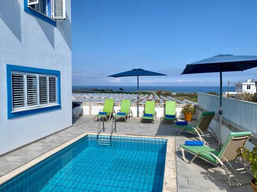 una piscina con sillas y sombrillas en el balcón en Villa Kapparis Sunrise, en Paralimni