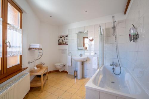 y baño con bañera, aseo y lavamanos. en Les Suites - La Cour St Fulrad, en Saint-Hippolyte