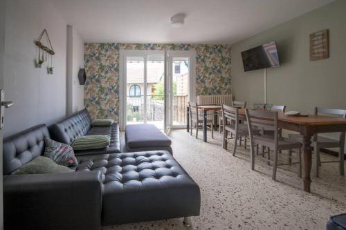un salon avec un canapé et une salle à manger dans l'établissement La cahute, appartement T2 avec jardin ou appartement familial T6, à Montauban