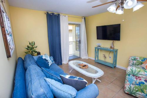 a living room with a blue couch and a tv at Island Wind Unit 303 in Fort Walton Beach