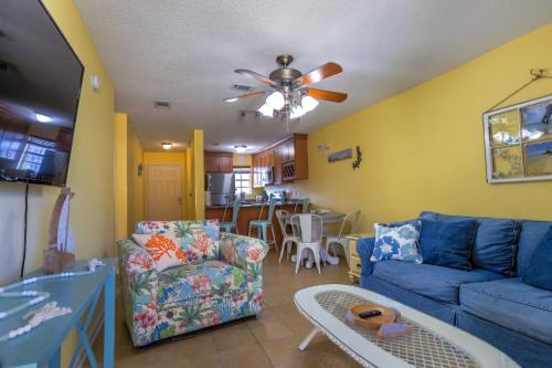 a living room with a blue couch and a ceiling fan at Island Wind Unit 303 in Fort Walton Beach