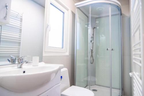 bagno bianco con lavandino e doccia di M&M Mobile home a Privlaka (Brevilacqua)