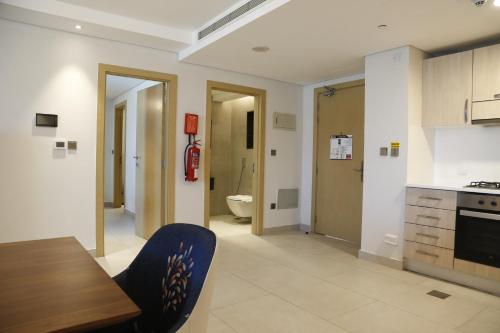 a kitchen with a dining table and a bathroom at Waterfront Hotel Apartment in Lusail