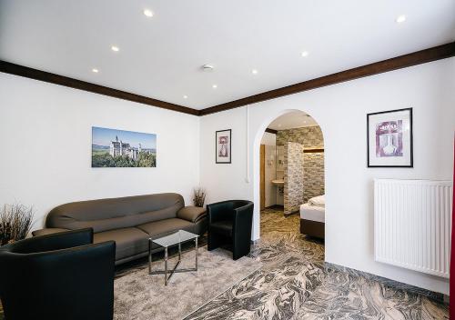 a living room with a couch and a bed at Central City Hotel in Füssen