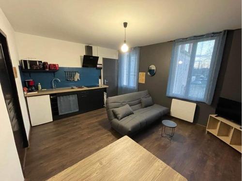 un salon avec un canapé et une cuisine dans l'établissement Appartement Calao, à Noyers-sur-Cher