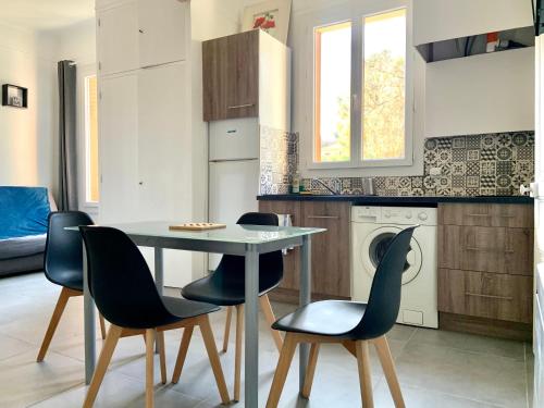 une cuisine avec une table et des chaises dans une pièce dans l'établissement Appartement ILIOS Cannes, au Cannet