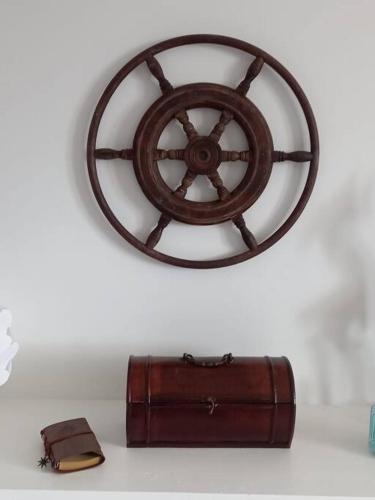 a wooden wheel on a wall next to a suitcase at Oblò sul Mare - Villa nel cuore del Salento in Lendinuso