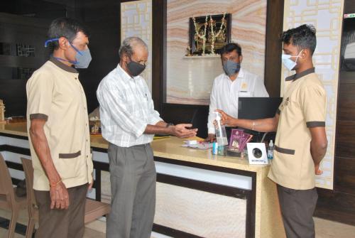 a group of men standing around a counter with masks on at Mysore Royale in Mysore