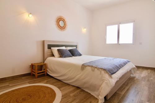 ein Schlafzimmer mit einem großen Bett und einem Spiegel an der Wand in der Unterkunft Lagoa Central by Homing in Lagoa