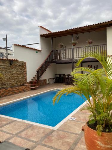 a villa with a swimming pool in front of a house at Hotel Boutique Colonial Cartago in Cartago