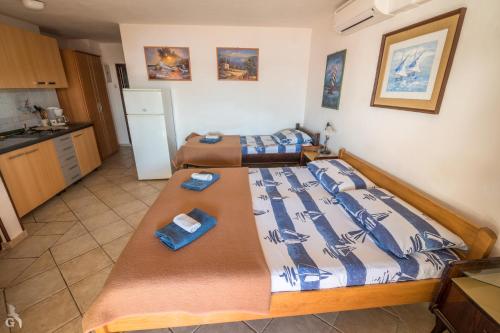 a bedroom with two beds and a kitchen at Villa Goga in Martinšćica