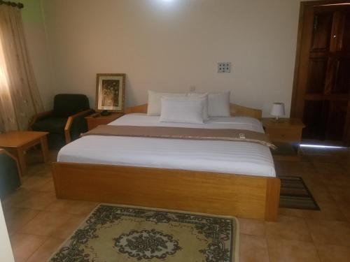 a bedroom with a large bed with white sheets at Neradom Hotel in Tema