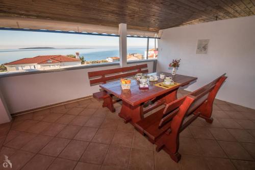 a dining room with a table and chairs and a view of the ocean at Villa Goga in Martinšćica