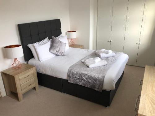 a bedroom with a large bed with two towels on it at Blue Sky Apartments@Guildford Town Centre in Guildford