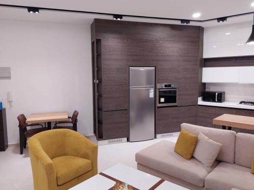 a living room with a couch and a refrigerator at Exquisite Modern 2-bedroom Rental Unit in Amman