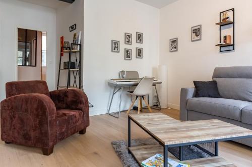 - un salon avec un canapé, une chaise et une table dans l'établissement Armstrong - Charmant logement au coeur de Nantes, à Nantes