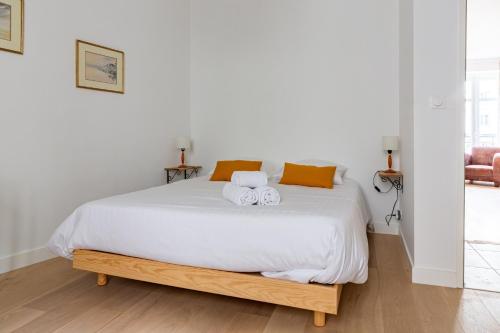 une chambre avec un lit blanc avec deux serviettes dessus dans l'établissement Armstrong - Charmant logement au coeur de Nantes, à Nantes