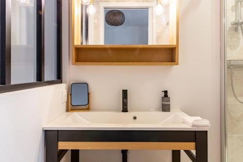 une salle de bain avec un lavabo et un miroir dans l'établissement Armstrong - Charmant logement au coeur de Nantes, à Nantes