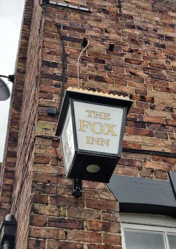 a street light on the side of a brick building at The Fox in Much Wenlock
