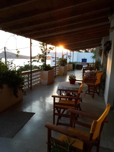 a patio with tables and chairs on a balcony at Sunset in Kalymnos
