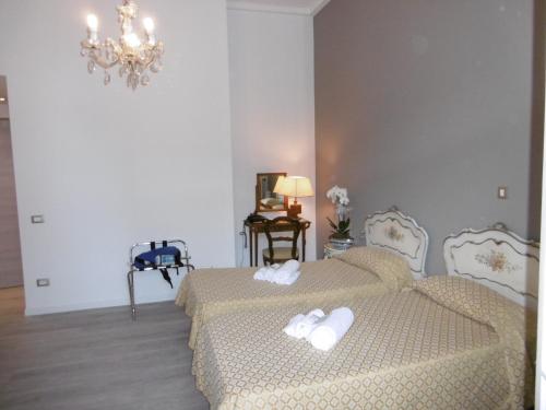 a bedroom with two beds and a chandelier at Hotel Villa Maria in Sanremo