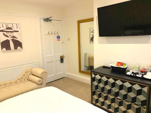 a bedroom with a bed and a television on a wall at The Malt House in Aylesbury