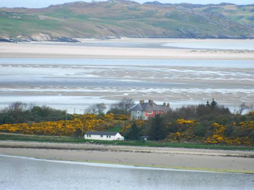 una casa su una collina vicino a un corpo d'acqua di Spectacular Highland Cottage Overlooking the Sea a Tongue