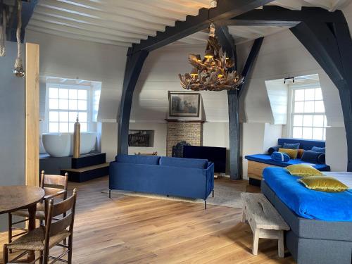 a living room with blue couches and a table at Auberge de Campveerse Toren in Veere
