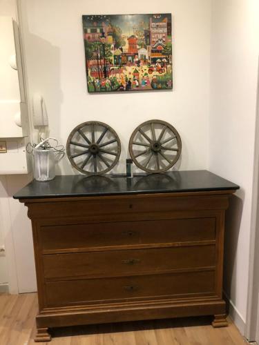 a wooden dresser with twookedoked wheels in a room at Le Cosy in Schiltigheim