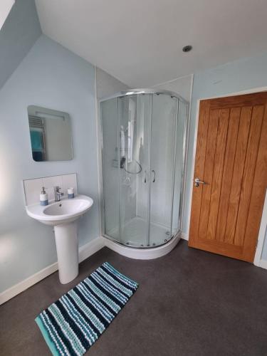 a bathroom with a glass shower and a sink at The Willow in Bristol