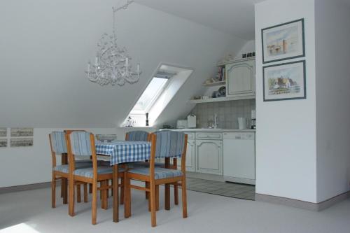 a kitchen with a table and chairs and a chandelier at Haus Burmeister in Tinnum