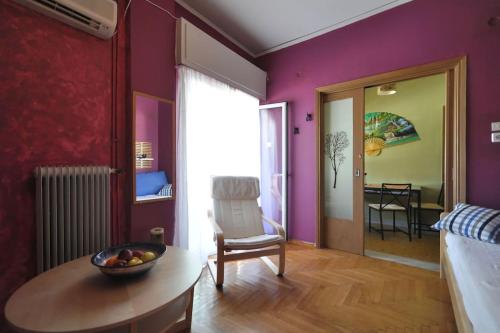 a bedroom with purple walls and a table and a chair at Nice Apartment Near City Center in Athens